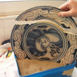 Gluing a delft ceramic ina a restoration of ceramics process