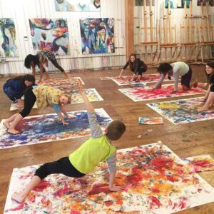 children painting with hands and feet in a museum